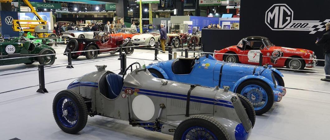 Two classic sportscars on a stand at the Rétromobile classic car show in Paris