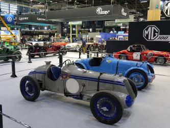 Two classic sportscars on a stand at the Rétromobile classic car show in Paris