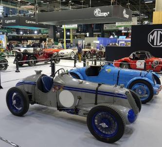 Two classic sportscars on a stand at the Rétromobile classic car show in Paris