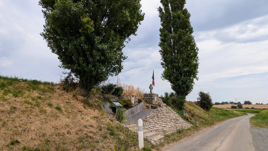 A sloping stone plinth built into the roadside bank