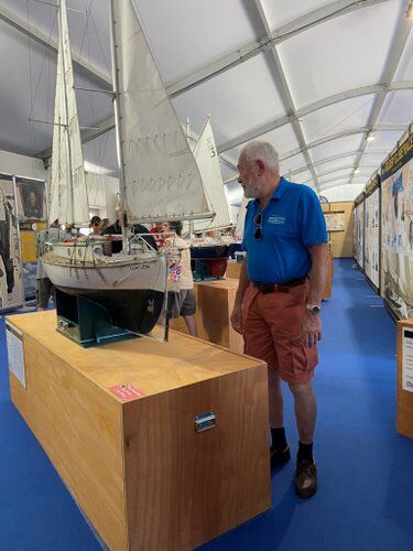 Sir Robin Know Johnston standing next to a large model of his boat