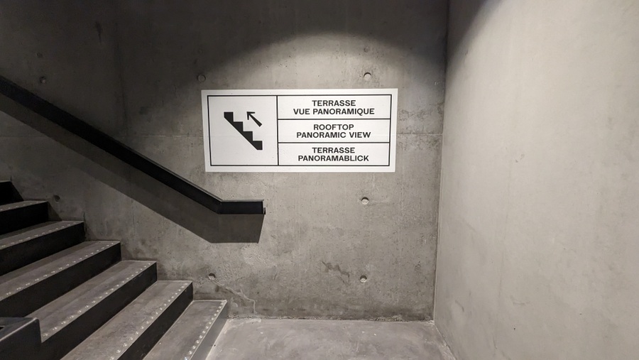 Staircase with a sign pointing to the roof terrace.