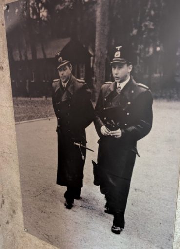 Two German Kriegsmarine officers in black leather coats walking and talking
