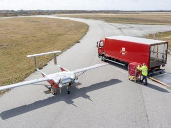 A Royal Mail UAV and parcel truck meet on the airfield