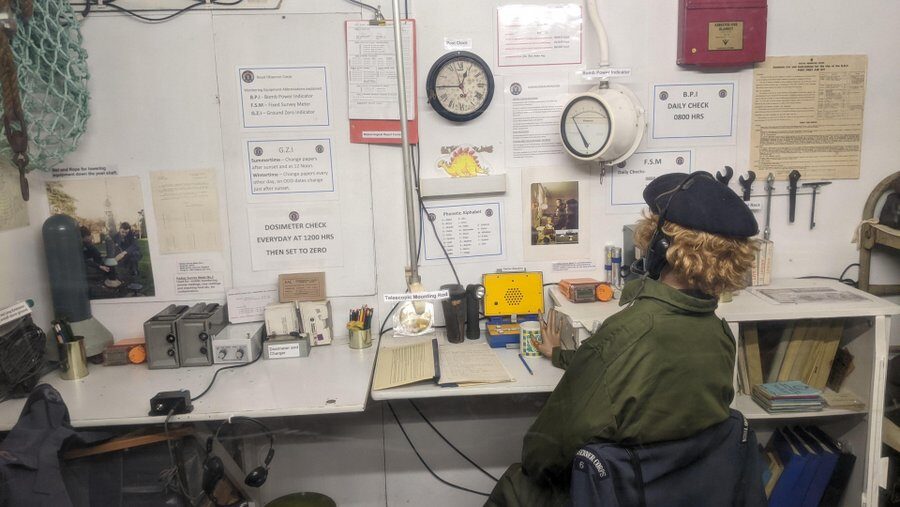 A uniformed mannequin sits at a desk in a replicated nuclear bunker