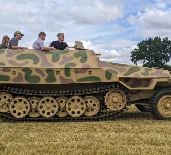 A camouflaged German half-track with passengers
