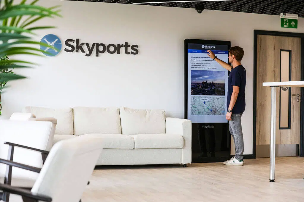 A man operates a digital display on the lounge wall