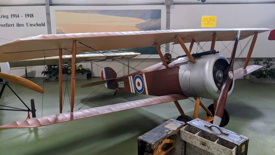 A brown Royal Flying Corps biplane with a silver engine cowling and roundels on the fuselage