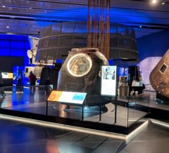 A large gallery of Space exhibits with a group of people talking to one side