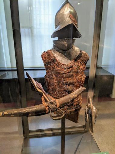 Crossbow, helmet and leather tunic on a mannequin
