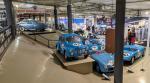Post-war race cars on display, mostly painted blue