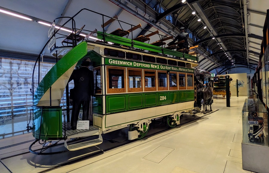 Large green and cream painted double-decker horse-drawn tram