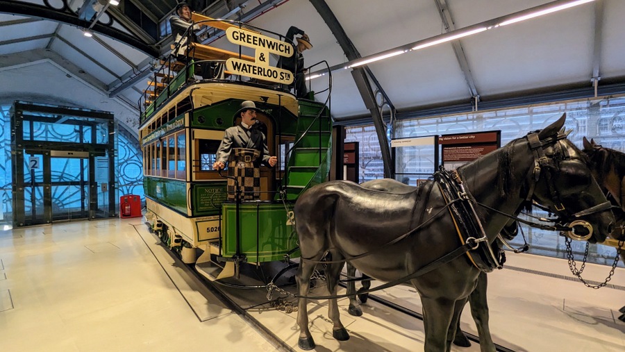 Large green and cream painted double-decker horse-drawn tram