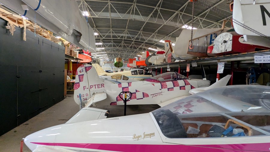View down a long row of aircraft in various states of disrepair, stored on the ground or on shelves