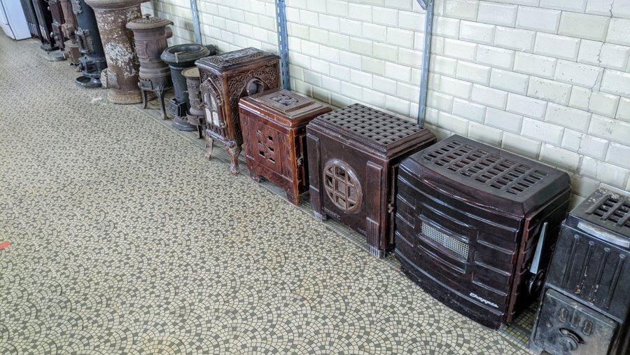 A row of old-fashioned heavy cast iron stoves and radiators