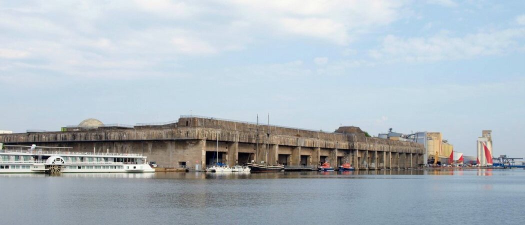 Huge grey concrete bunker with fourteen protected docks for submarines