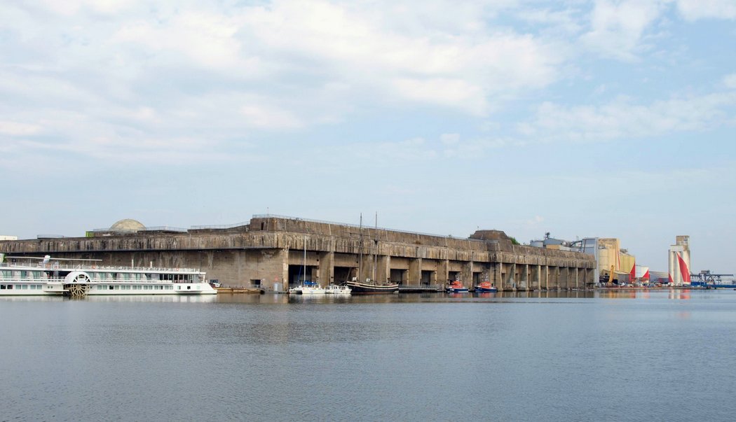 Huge grey concrete bunker with fourteen protected docks for submarines