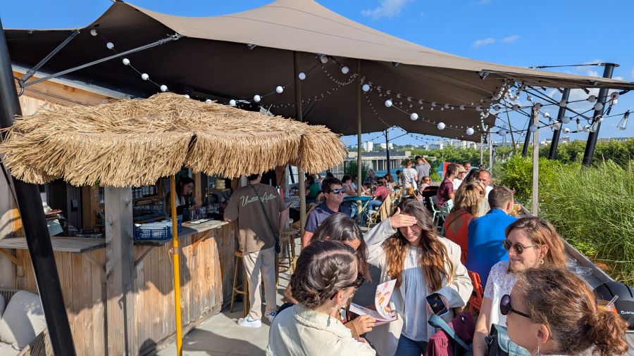 A busy rooftop bar on a sunny evening