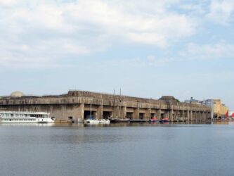 View across the water to grey concrete submarine pens