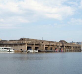 View across the water to grey concrete submarine pens