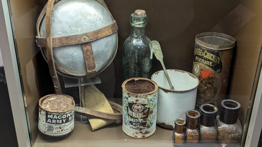 Display case with a drinking flask and food tins