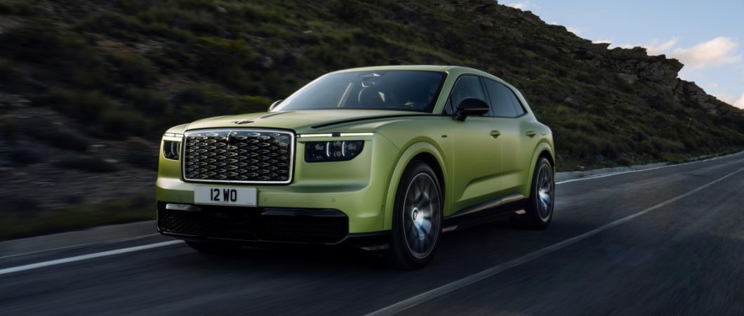 A greeny golden glamourous estate car on a mountain road