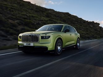 A greeny golden glamourous estate car on a mountain road