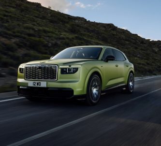 A greeny golden glamourous estate car on a mountain road