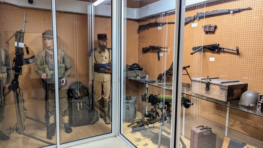 Uniformed mannequins and small arms in display cases