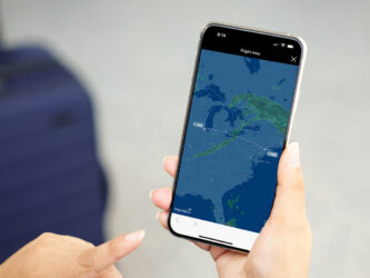 A hand holds a mobile phone with a weather map displayed on it.