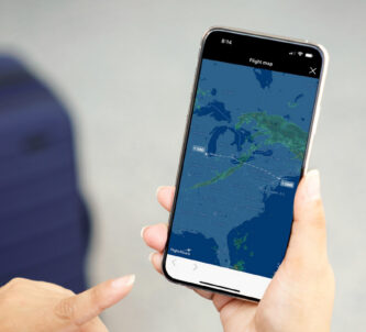 A hand holds a mobile phone with a weather map displayed on it.
