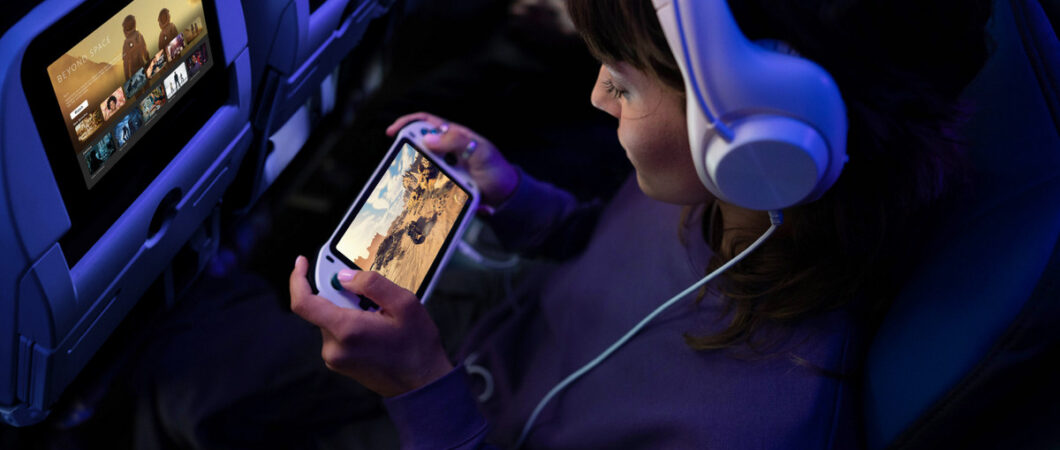 A child plays on their console in their aircraft seat