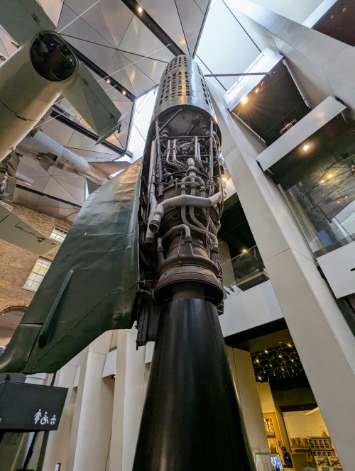 View from the base of a large V2 rocket with some sections of the fuselage cutaway to expose the engine