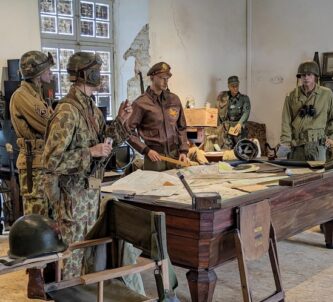 Soldiers (mannequins) stand around a table with maps