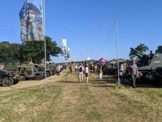 A grassy avenue at We Have Ways Fest with military vehicles displayed on both sides