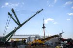 A large crane starts to lift the foremast off HMS Victory
