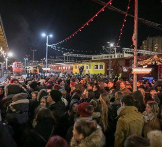Music gig audience dress warmly with historic locomotives behind