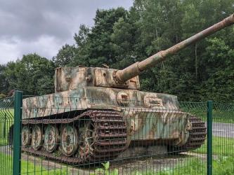 Tiger tank in faded camouflage behind its protective green fence