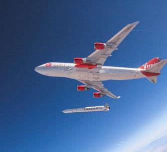 A red and white painted Virgin jumbo jet high in the blue atmosphere... drops a rocket from under its wing!