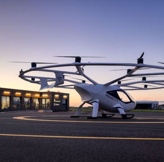 A eVTOL aircraft in evening light on the ground at at test vertiport building