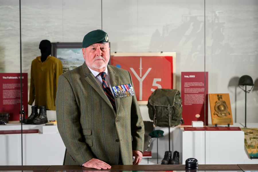 Royal Marine William MacPherson standing by the display of his Falklands boots and beret