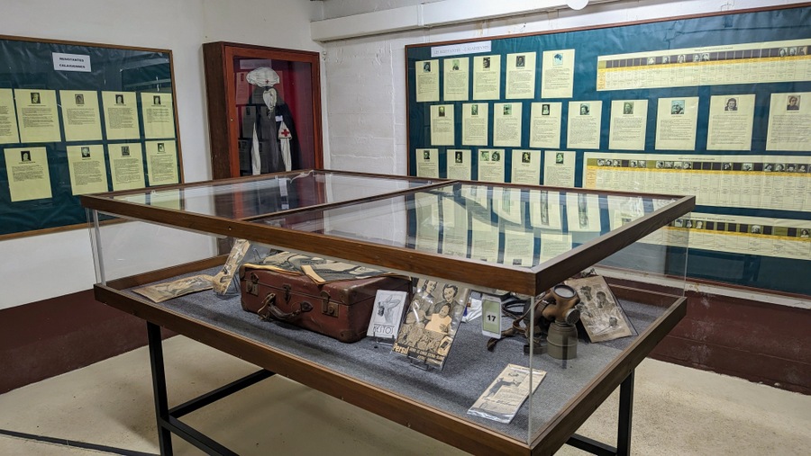 A room with displays on the walls and display case table in the middle