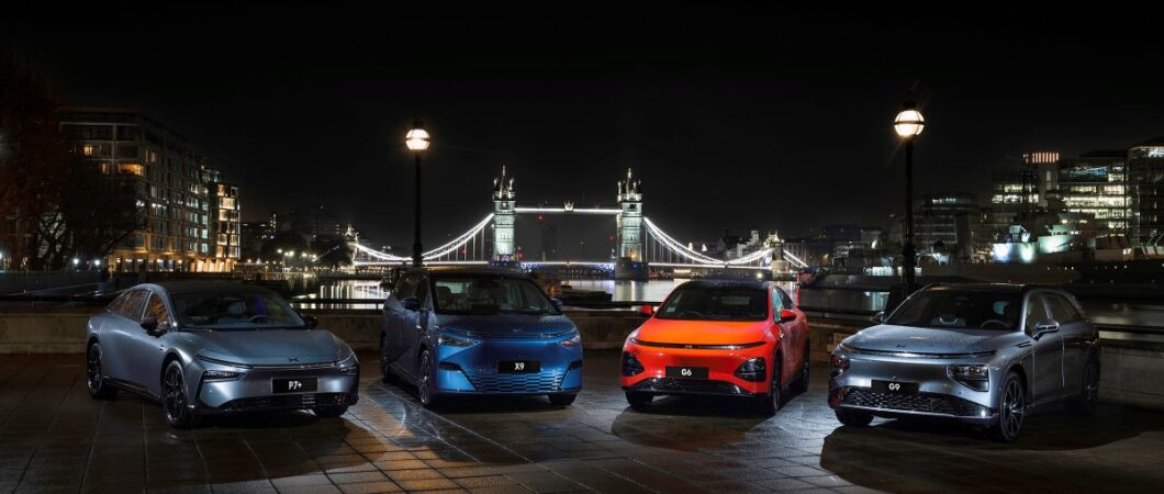 A set of fours electric cars are displayed at night in London with Tower bridge in the background