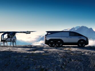 AI rendered image of a small multi-rotor eVTOL and a futuristic silver six-wheeled vehicle on a mountain ledge