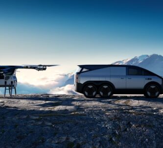 AI rendered image of a small multi-rotor eVTOL and a futuristic silver six-wheeled vehicle on a mountain ledge