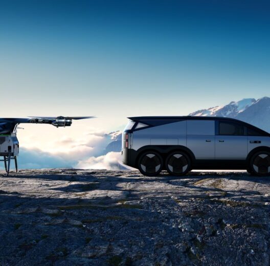 AI rendered image of a small multi-rotor eVTOL and a futuristic silver six-wheeled vehicle on a mountain ledge