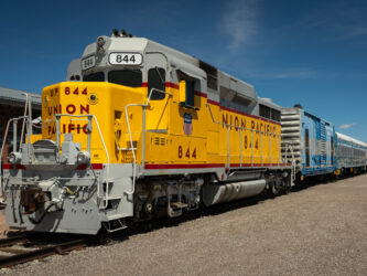 A yellow Pacific Union diesel-electric locomotive waits by the Nevada Stat Railroad Museum station platform