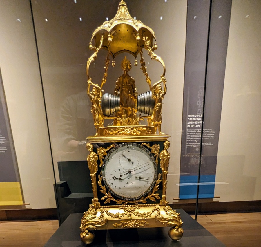 An ornate gold clock with a turbaned figure on top