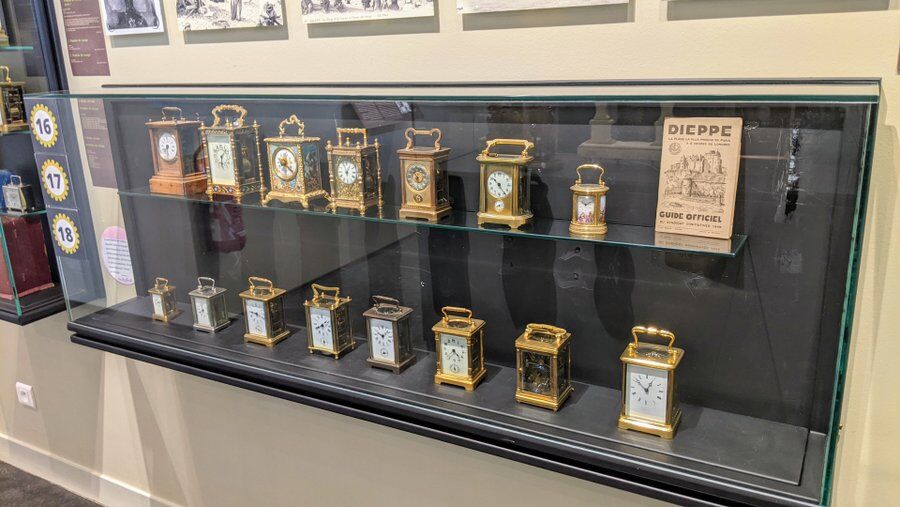 A display cabinet full of ornate carriage clocks