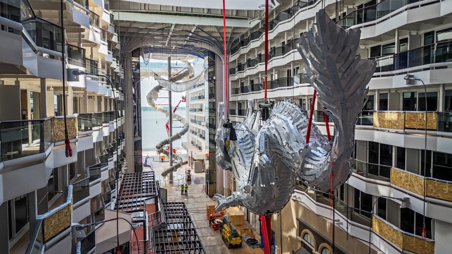 A giant silver Chinese dragon is hauled into position in the interior gallery on the ship